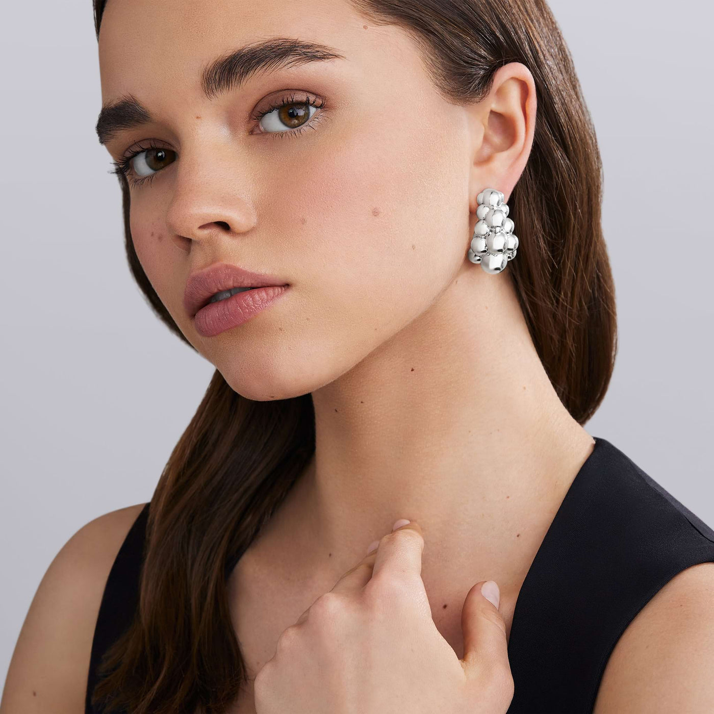 woman wearing three-row beaded sterling silver statement hoop earrings