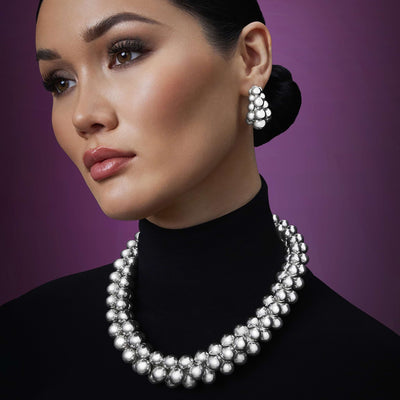 woman wearing sterling silver beaded statement necklace and earrings